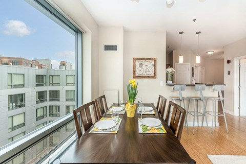 50 WB's furnished apartment showing a dining room with a large window and a table with chairs